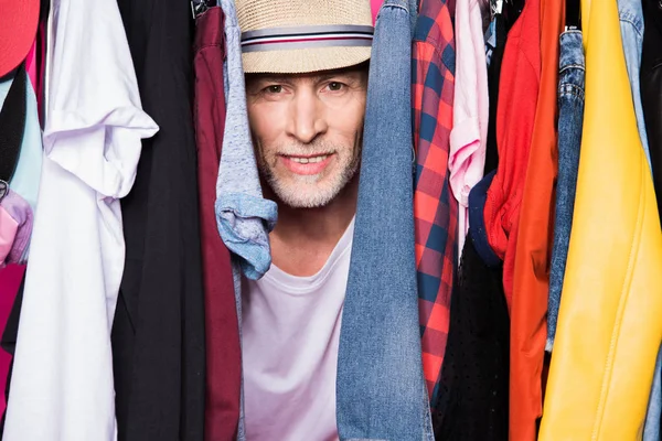 Senior homme avec des vêtements diferents sur cintres — Photo de stock