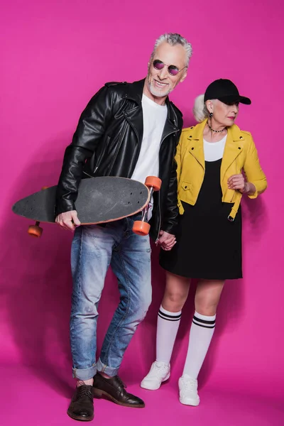 Senior couple with skateboard — Stock Photo