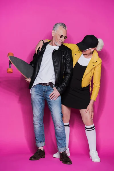 Senior couple with skateboard — Stock Photo