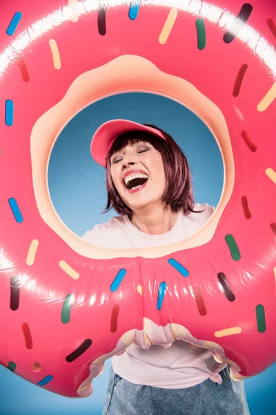 Mujer riendo y sosteniendo anillo de flotador - foto de stock