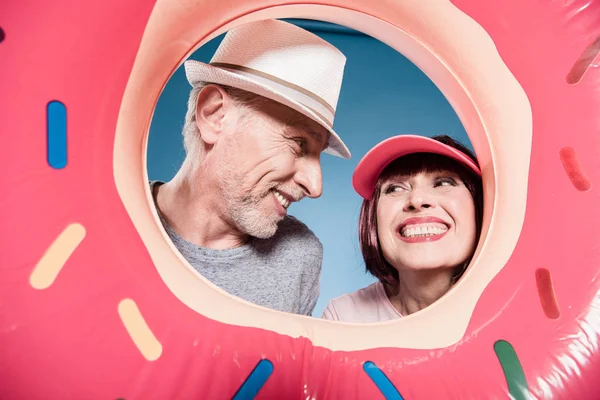 Elderly couple smiling into swimming tube — Stock Photo