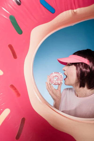 Femme mangeant beignet dans le tube de natation — Photo de stock