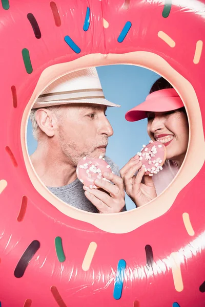 Casal idoso comer donuts doces — Fotografia de Stock
