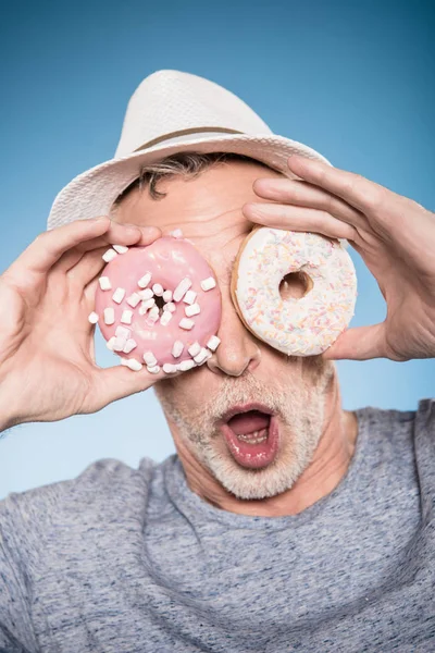 Man holding donuts in front of eyes — Stock Photo