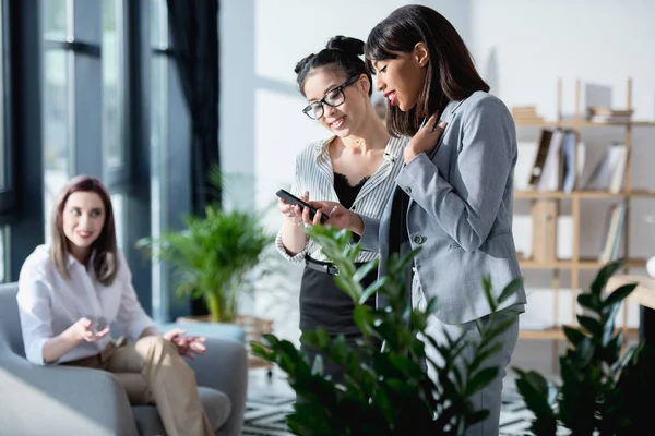 Las mujeres de negocios utilizando smartphone - foto de stock