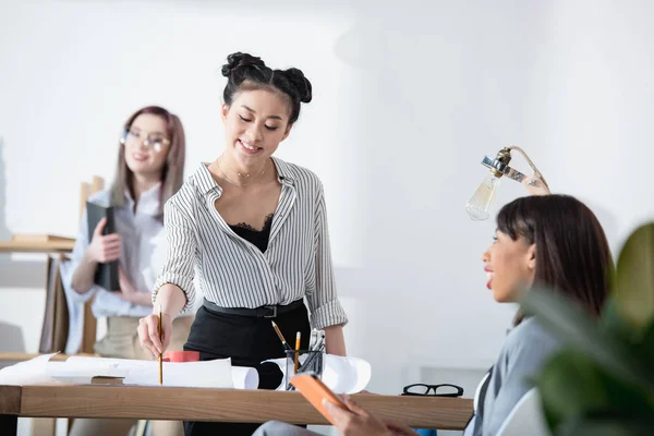 Empresarias multiétnicas que trabajan en la oficina - foto de stock