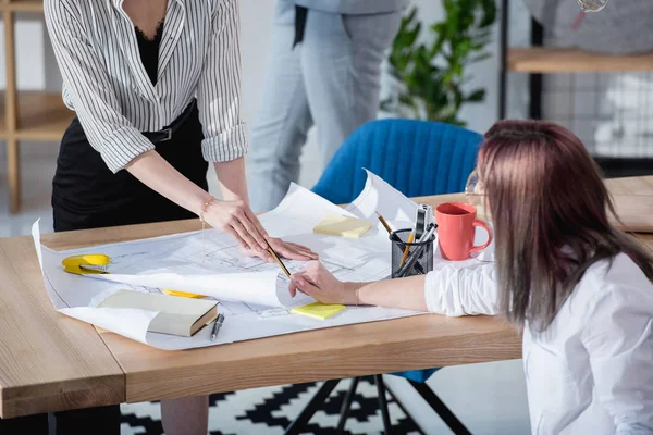 Designers travaillant avec des plans au bureau — Photo de stock