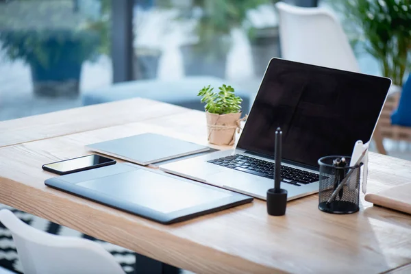 Portátil y tableta gráfica con teléfono inteligente en la mesa - foto de stock