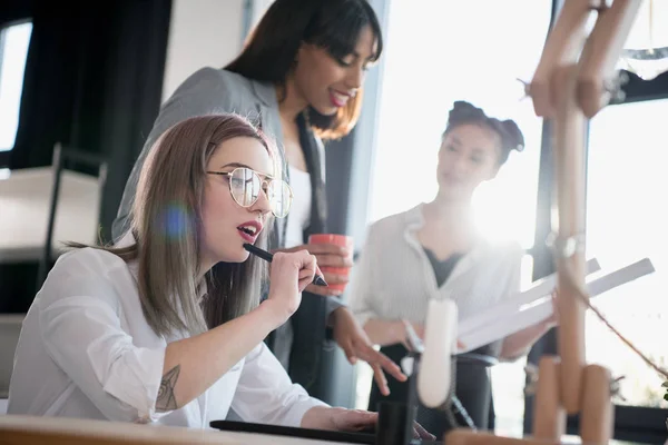 Jóvenes diseñadores multiétnicos que trabajan en la oficina - foto de stock