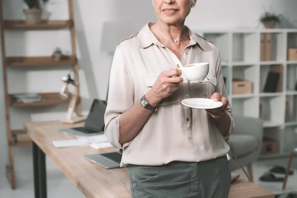 Femme d'affaires avec café au bureau — Photo de stock