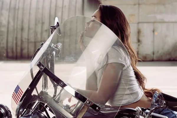 Jeune femme assise sur la moto — Photo de stock