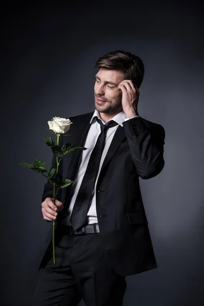 Чоловік у костюмі тримає білу троянду — стокове фото