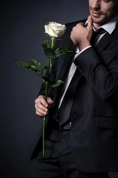 Чоловік у костюмі тримає білу троянду — стокове фото