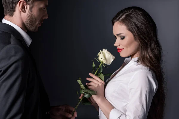 Мужчина представляет белую розу девушке — стоковое фото
