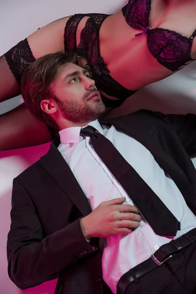 Homem elegante deitado perto da menina em lingerie — Fotografia de Stock