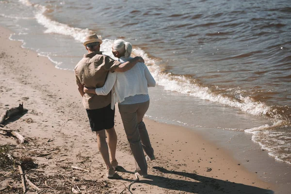 Seniorenpaar geht am Strand spazieren — Stockfoto