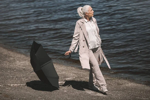 Mujer mayor con paraguas - foto de stock