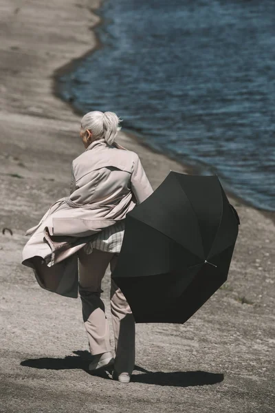 Mujer mayor con paraguas - foto de stock