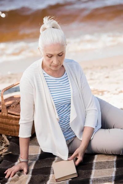 Старша жінка на березі річки — стокове фото