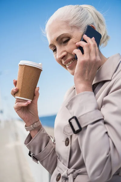 Mujer de pelo gris hablando en smartphone - foto de stock