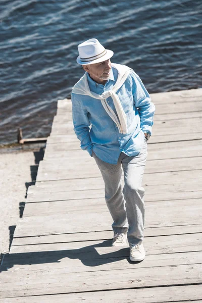 Homem sênior na moda andando na beira do rio — Fotografia de Stock