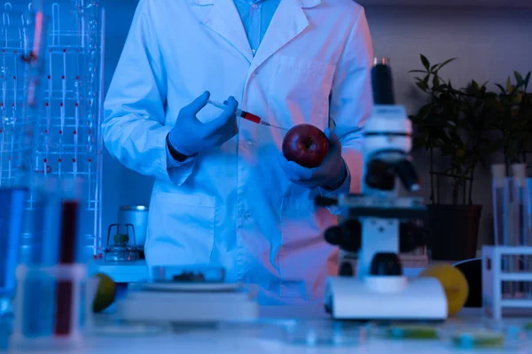 Wissenschaftler mit Spritze und Apfel — Stockfoto