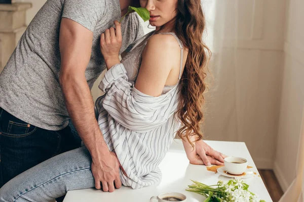 Casal sensual em preliminares na mesa em casa — Fotografia de Stock