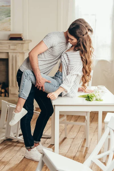 Pareja apasionada en el juego previo en la mesa en casa - foto de stock