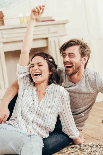 Couple laughing and fooling around with puzzles — Stock Photo