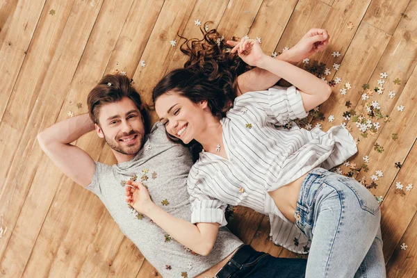 Joven sonriente pareja acostada en el suelo - foto de stock