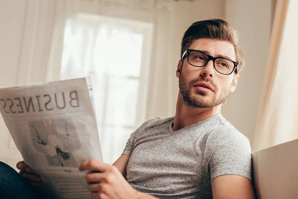 Junger Mann liest Zeitung zu Hause — Stockfoto