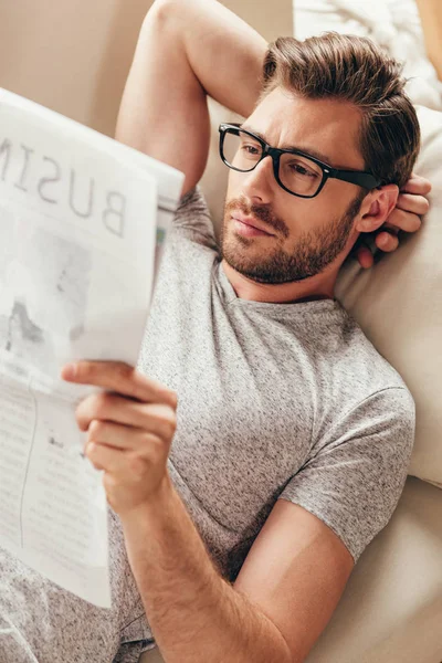 Junger Mann liest Zeitung zu Hause — Stockfoto