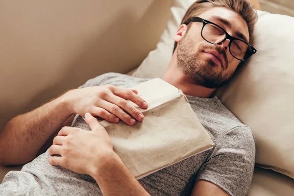 Jovem dormindo com livro em casa — Fotografia de Stock