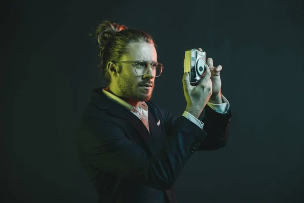 Man in tuxedo taking photo on camera — Stock Photo