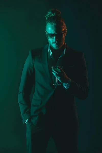 Man in tuxedo holding glass with cocktail — Stock Photo