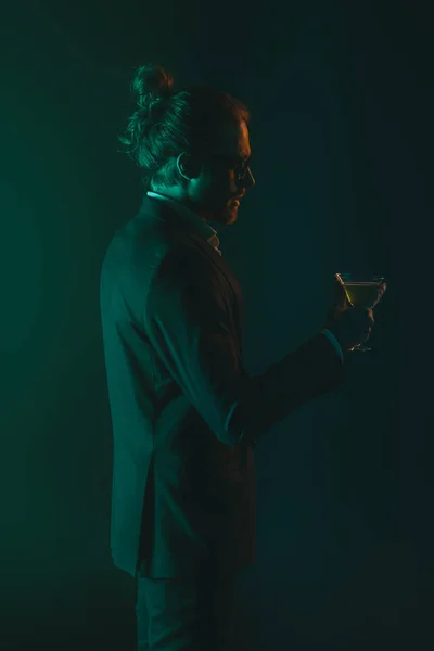 Man in tuxedo holding glass with cocktail — Stock Photo