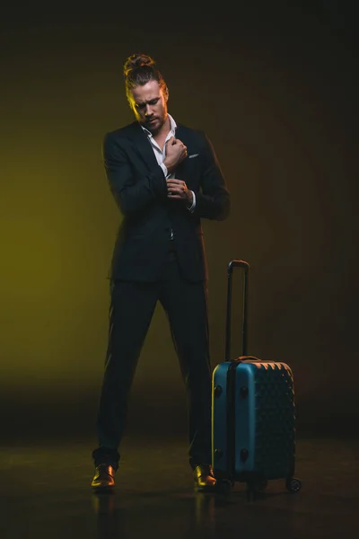 Caucásico hombre en esmoquin de pie cerca de la maleta — Stock Photo