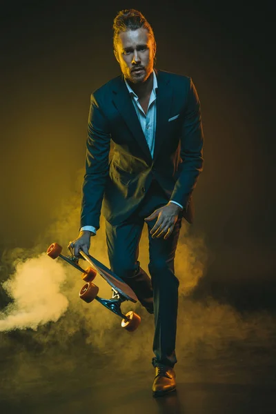 Homme en costume équitation sur skateboard — Photo de stock