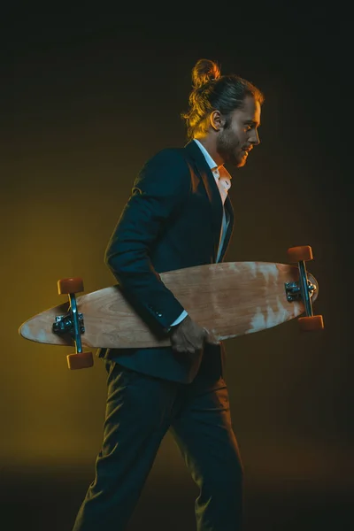 Homem de smoking correndo com skate — Fotografia de Stock