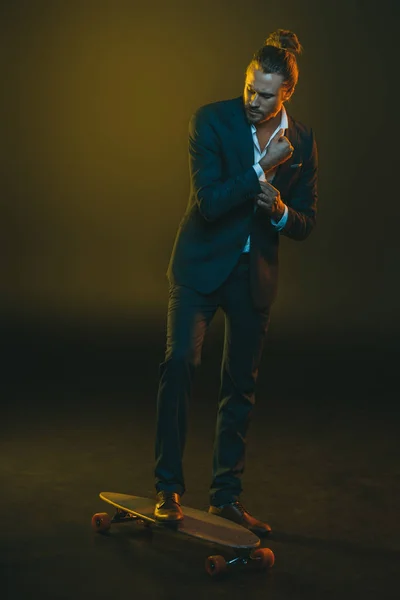 Homem em elegante smoking equitação no skate — Fotografia de Stock