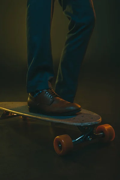 Homme en tenue formelle équitation sur skateboard — Photo de stock