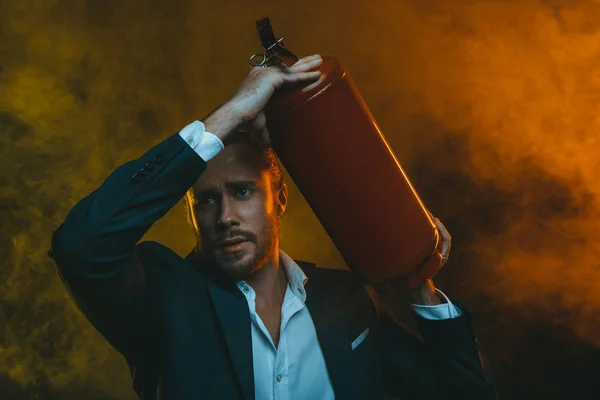 Man in suit holding fire extinguisher — Stock Photo