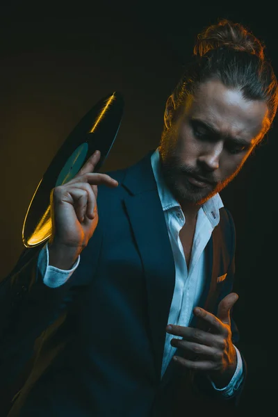 Man in tuxedo holding vinyl record — Stock Photo