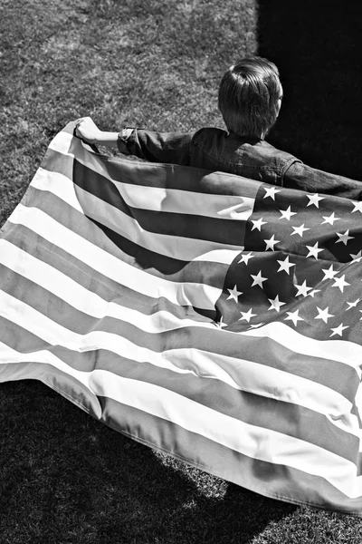 Niño corriendo con bandera americana - foto de stock