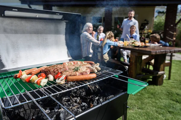 Meat and vegetables cooking on grill — Stock Photo