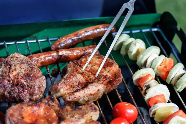 Meat pricked by carving fork on grill — Stock Photo