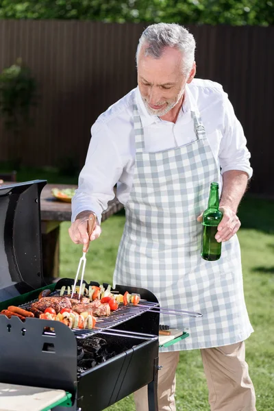 Uomo dai capelli grigi preparare barbecue — Foto stock