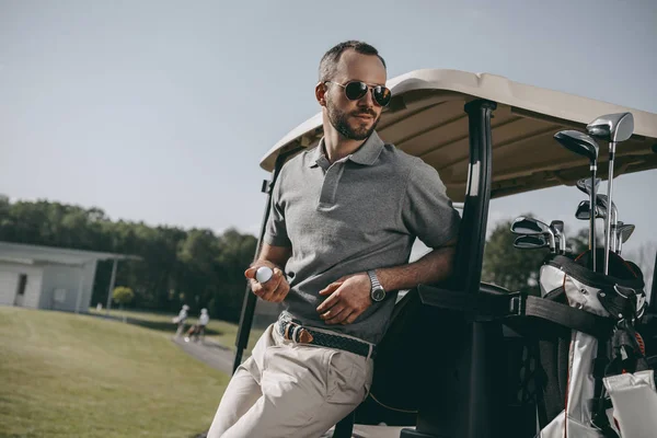 Stylish golfer holding golf ball — Stock Photo