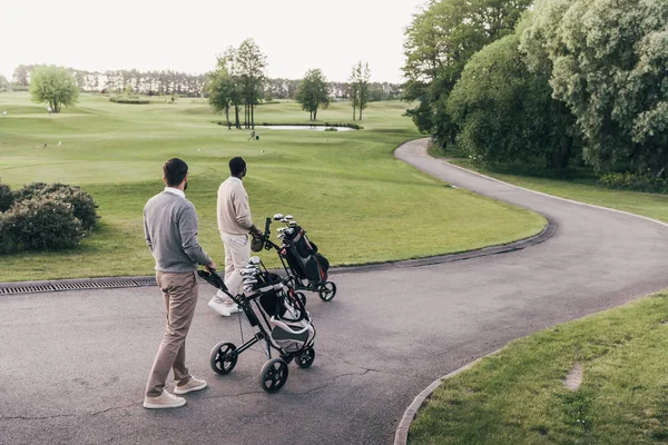 Hombres con palos de golf en bolsas - foto de stock