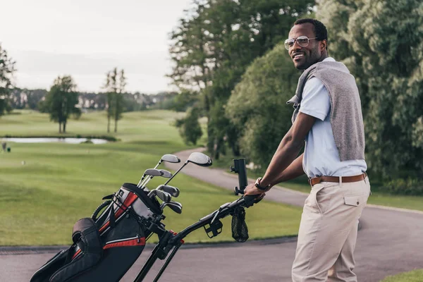 Hombre con palos de golf en bolsa - foto de stock